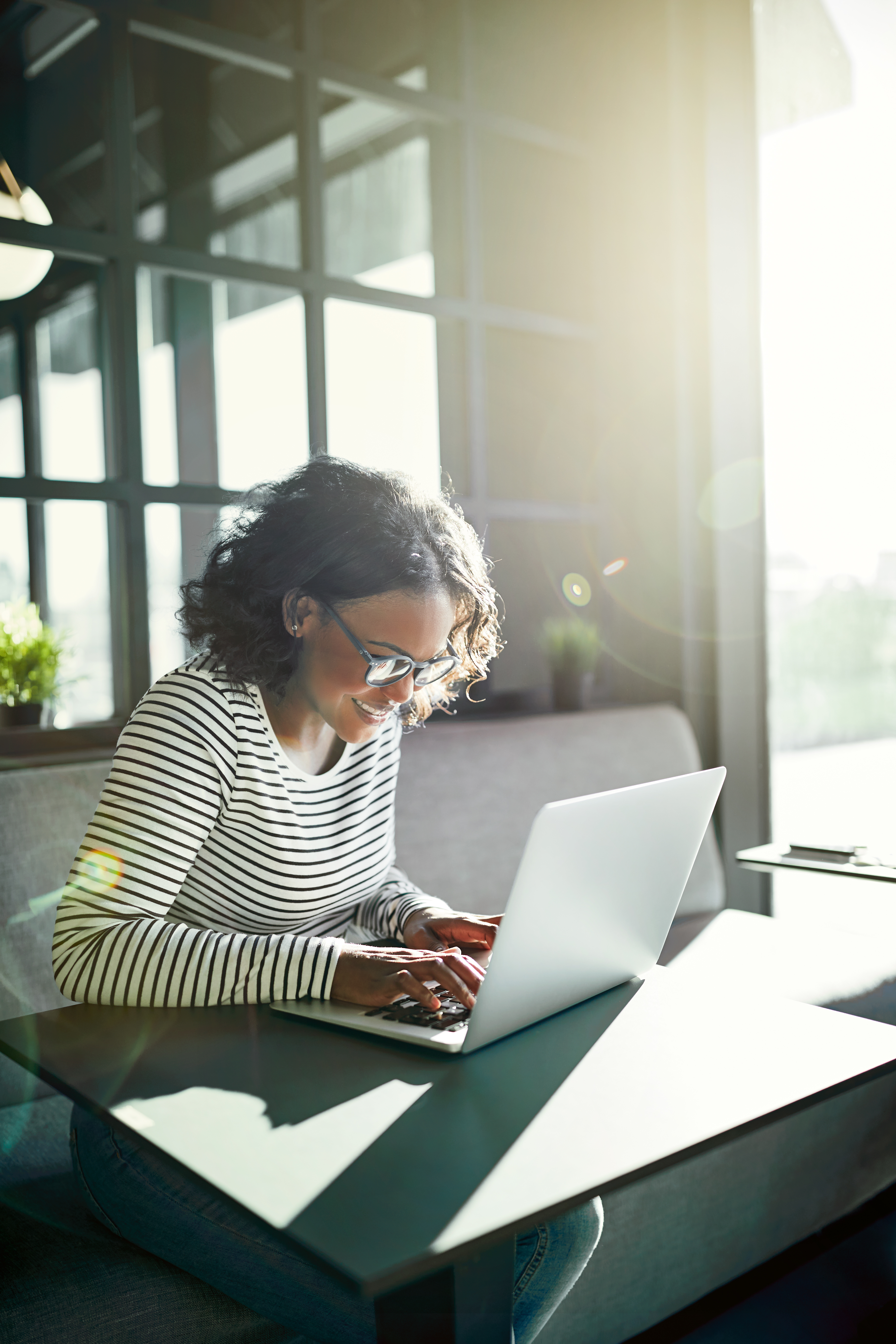 Smiling young African woman working on laptop for marketing automation